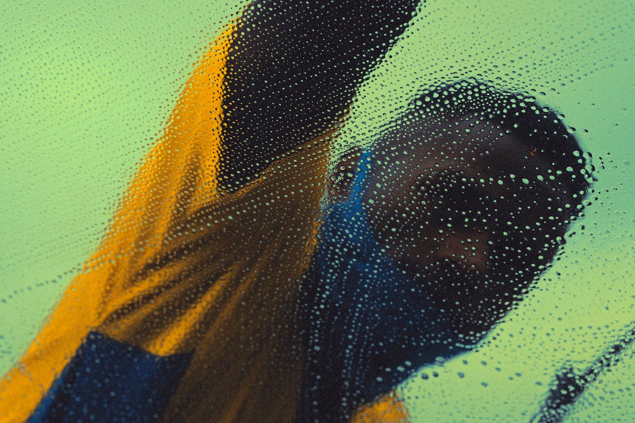 Anonymous man in São Paulo washing glass with soap and bubbles, creating a blurred effect.